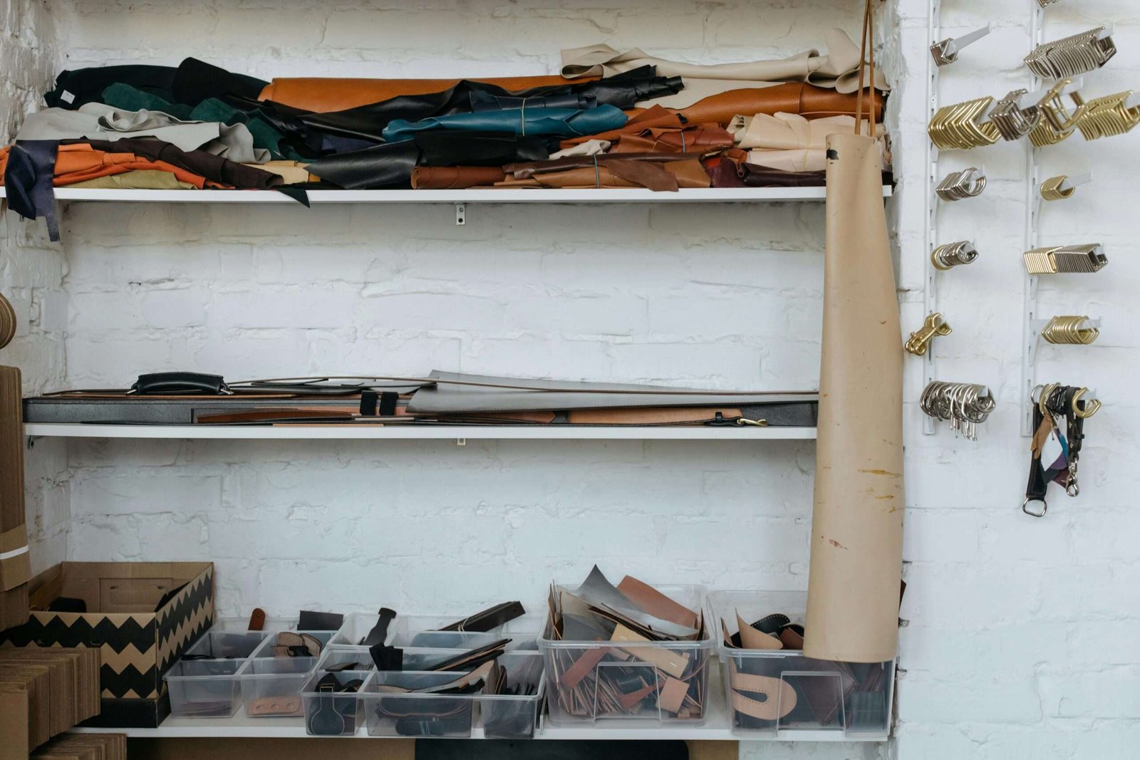 Organized leather crafts materials on shelves in a contemporary workshop setting.