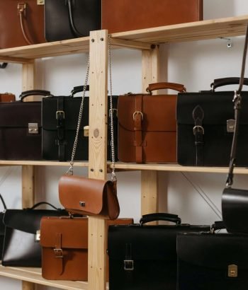 A stylish selection of leather bags showcased on wooden shelves, emphasizing luxury fashion accessories.